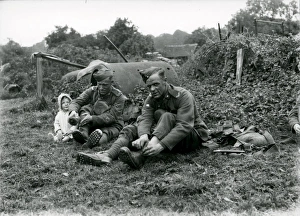 Boots Prints: Lewis Gunners. East Yorks Regiment sitting talking to young child, August 1936