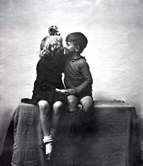 Images Dated 15th October 2012: Young boy and girl kissing under mistletoe