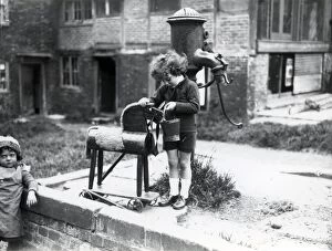 Images Dated 5th December 2012: Young child pretending to water a wooden horse, August 1923